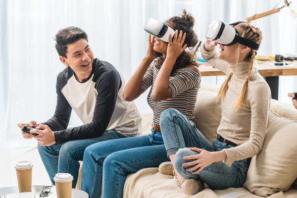 teens wearing virtual reality googles on couch